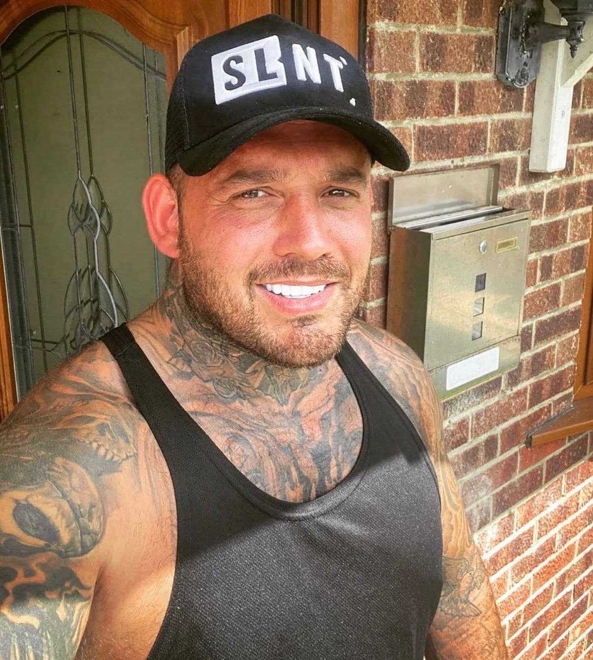Black SLNT trucker cap worn with a black vest